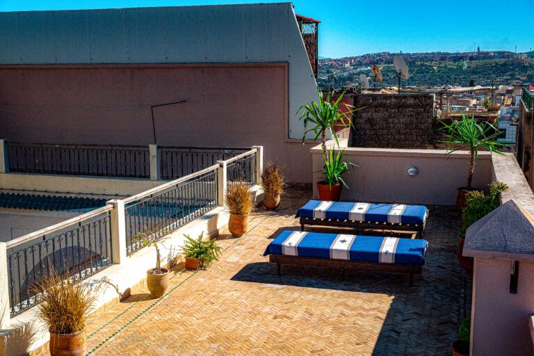 Rooftop terrace with deckchairs overlooking the Fez medina